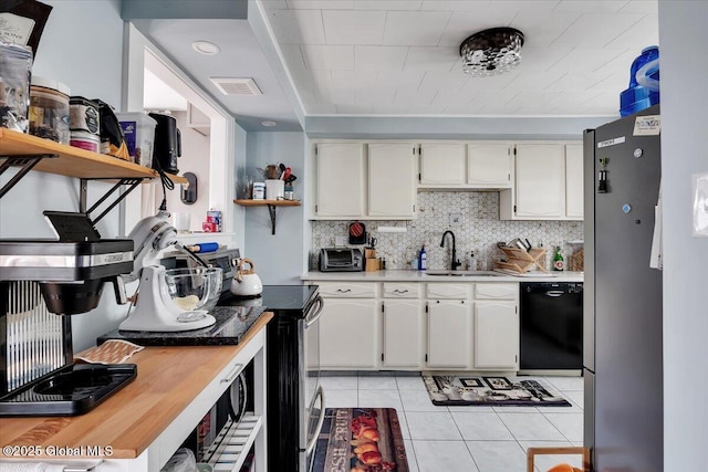 kitchen with a sink, stainless steel appliances, backsplash, and light countertops