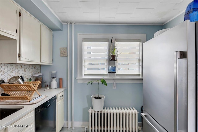 kitchen featuring radiator, dishwasher, light countertops, decorative backsplash, and freestanding refrigerator