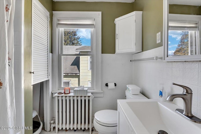 bathroom with radiator, vanity, and toilet