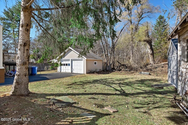 view of yard with a detached garage, an outdoor structure, and fence