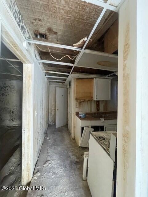 interior space with a sink, an ornate ceiling, and white cabinetry