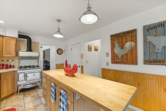 155 Andrews Rd, Carlisle, NY 12160 - kitchen featuring a wood stove, gas range, wall chimney range hood, decorative light fixtures, and butcher block counters