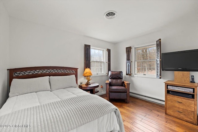 155 Andrews Rd, Carlisle, NY 12160 - bedroom with hardwood / wood-style floors, multiple windows, visible vents, and baseboard heating