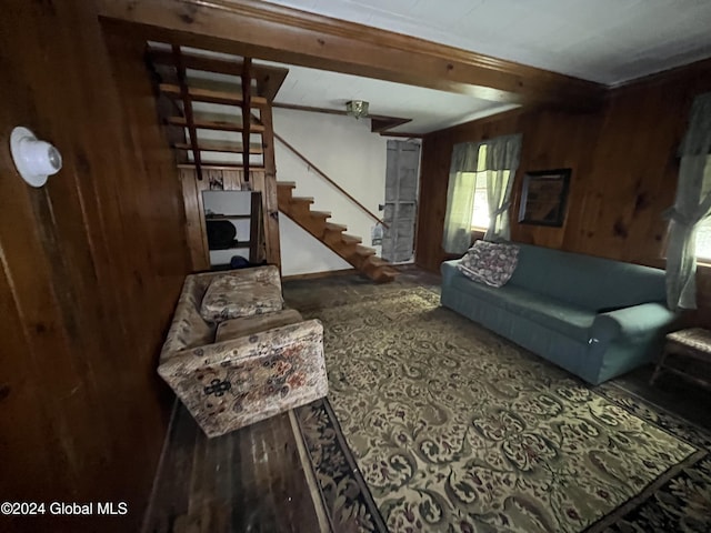 living room featuring stairway and wood walls