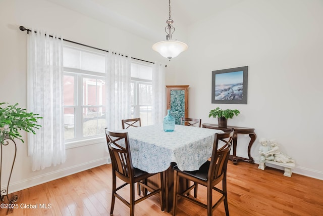 dining space with light wood-style flooring and baseboards