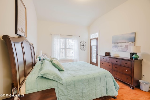 bedroom with light wood-style flooring and vaulted ceiling