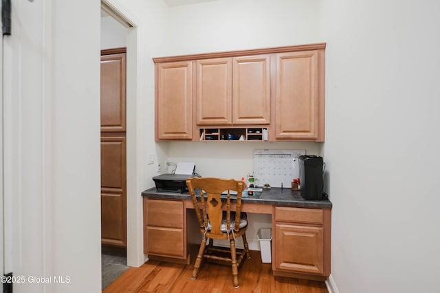 home office featuring built in desk and light wood-type flooring