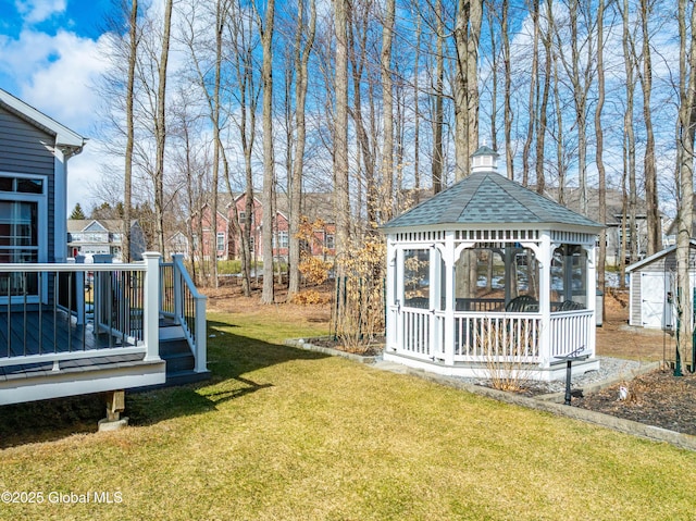 view of yard with a gazebo, a storage unit, an outbuilding, and a wooden deck