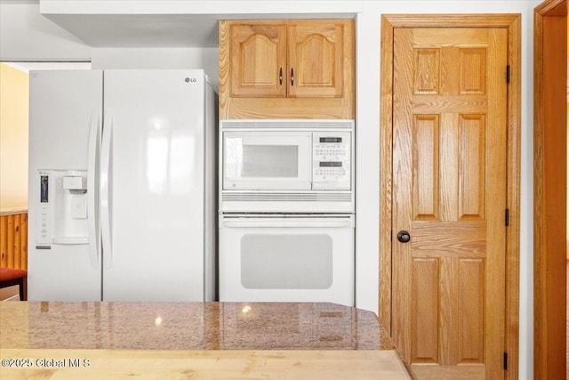 kitchen featuring white appliances and light stone countertops