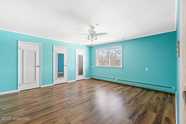 unfurnished bedroom featuring baseboards, a ceiling fan, a baseboard radiator, wood finished floors, and two closets