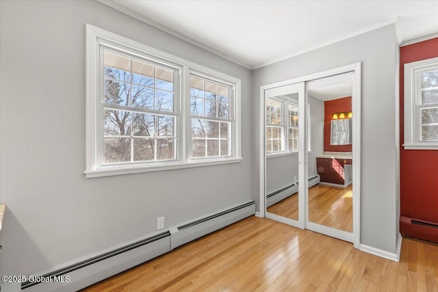 bedroom with light wood-style floors, a baseboard radiator, and ornamental molding