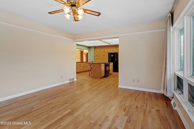 unfurnished living room featuring a ceiling fan, visible vents, baseboards, and light wood-type flooring