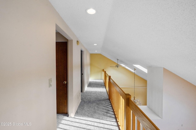 hallway featuring recessed lighting, vaulted ceiling, a textured ceiling, light carpet, and an upstairs landing