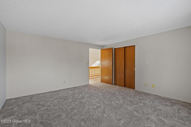 unfurnished bedroom featuring a closet, a textured ceiling, and carpet