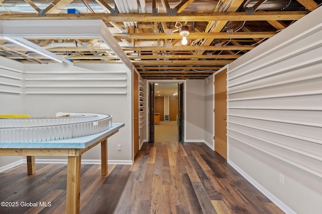 below grade area featuring baseboards and dark wood-type flooring