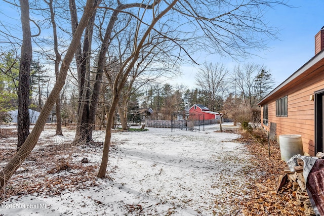 yard covered in snow featuring fence