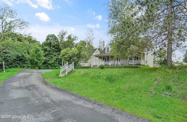 18 Johnson Ln, Poestenkill, NY 12018 - view of front facade with covered porch, a chimney, and asphalt driveway