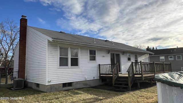 back of house featuring central air condition unit, a chimney, a lawn, and a wooden deck