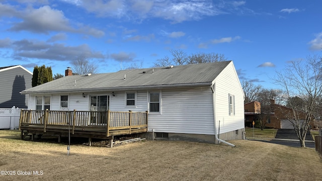 rear view of house with driveway, fence, and a wooden deck