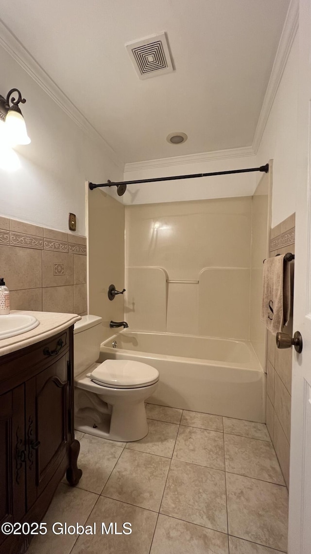 bathroom with visible vents, toilet, ornamental molding, tile patterned floors, and tile walls