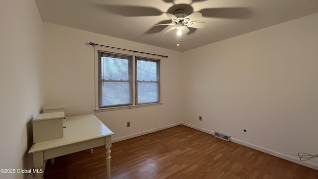 interior space featuring a ceiling fan, baseboards, visible vents, and wood finished floors