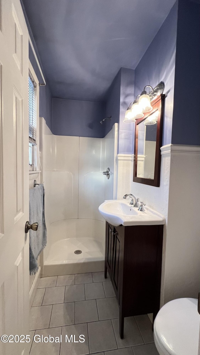 full bathroom with a stall shower, tile patterned flooring, vanity, and toilet