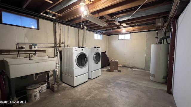 clothes washing area with washing machine and dryer, laundry area, water heater, and a sink