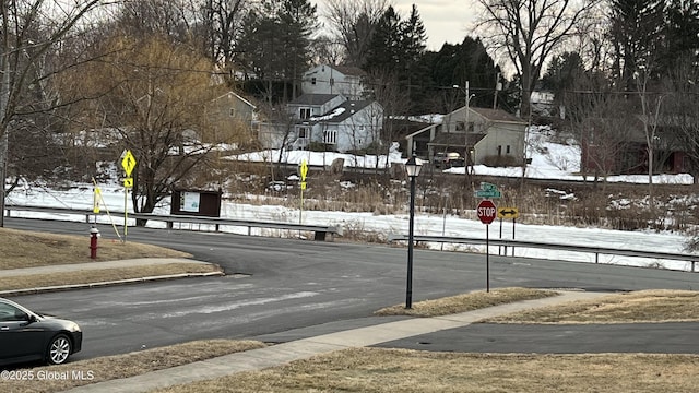 view of street with sidewalks, traffic signs, and a residential view