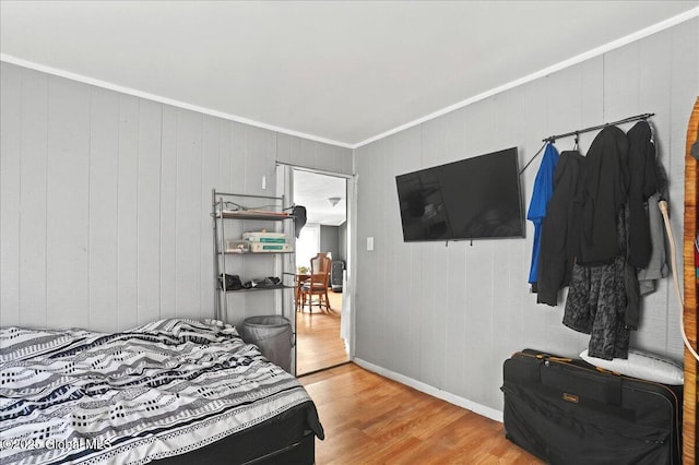 bedroom featuring wood finished floors, baseboards, and ornamental molding