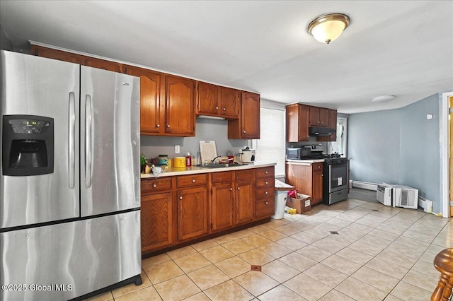 kitchen with a sink, under cabinet range hood, stainless steel appliances, light countertops, and light tile patterned floors