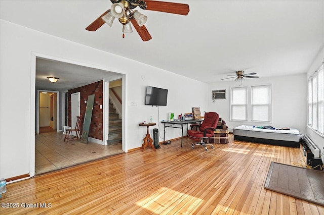 office area featuring hardwood / wood-style floors, baseboards, ceiling fan, and a wall unit AC