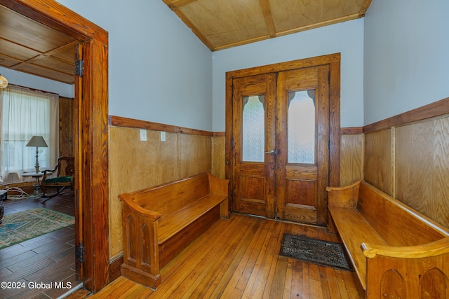 entrance foyer with hardwood / wood-style floors, wood walls, and wainscoting