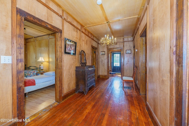 entryway featuring dark wood-style floors, baseboards, and an inviting chandelier