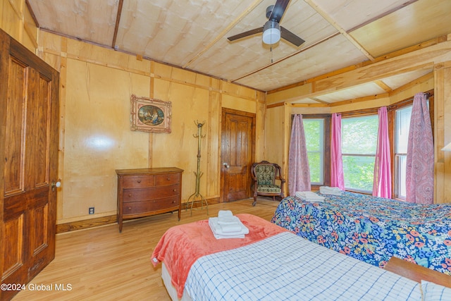 bedroom with wood walls and light wood-style flooring