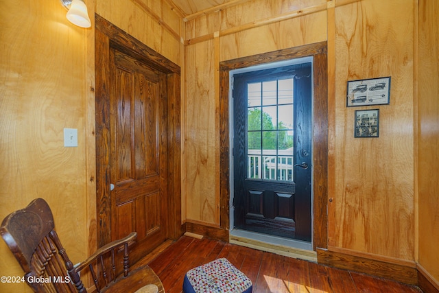 entryway featuring dark wood-style flooring and wood walls