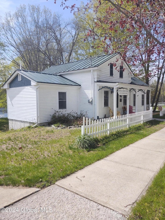 view of front of home with a fenced front yard, a standing seam roof, and metal roof