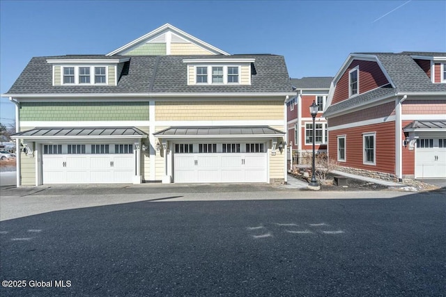 view of front of house with metal roof, roof with shingles, and a standing seam roof