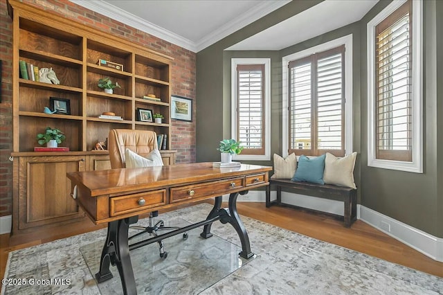 office space with baseboards, brick wall, wood finished floors, and crown molding