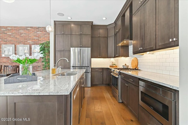 kitchen with dark brown cabinets, stainless steel appliances, and a sink