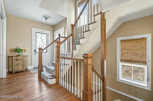 stairs featuring hardwood / wood-style floors and baseboards