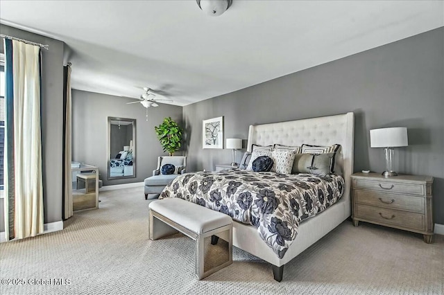 bedroom featuring light colored carpet, a ceiling fan, and baseboards