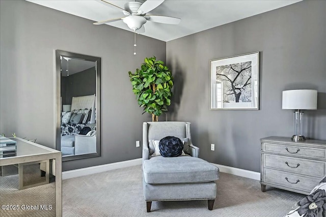 sitting room featuring baseboards, carpet, and a ceiling fan