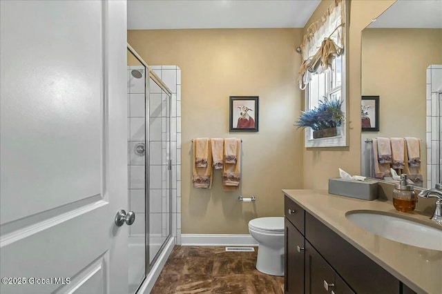 bathroom with visible vents, a shower stall, baseboards, toilet, and vanity