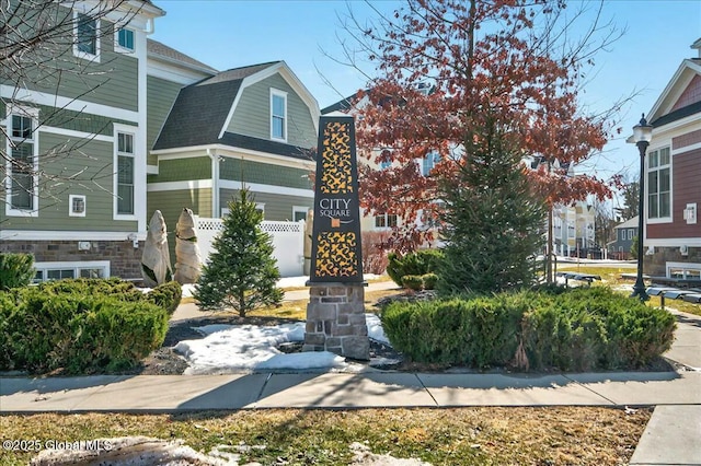 exterior space featuring a gambrel roof and a shingled roof