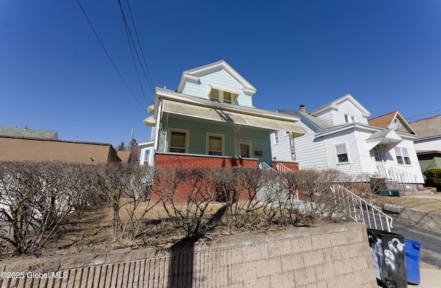 view of front of house featuring brick siding and a porch