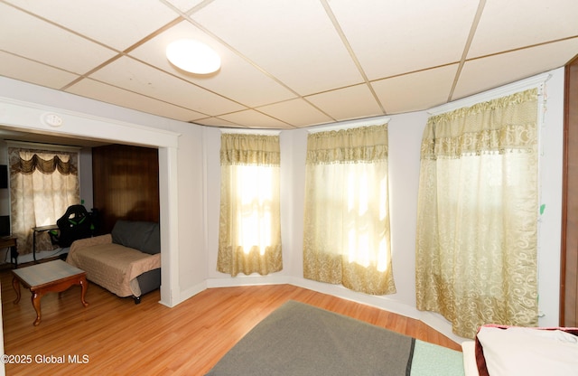 sitting room with a paneled ceiling and wood finished floors