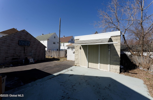 back of property featuring a storage shed, an outdoor structure, and fence