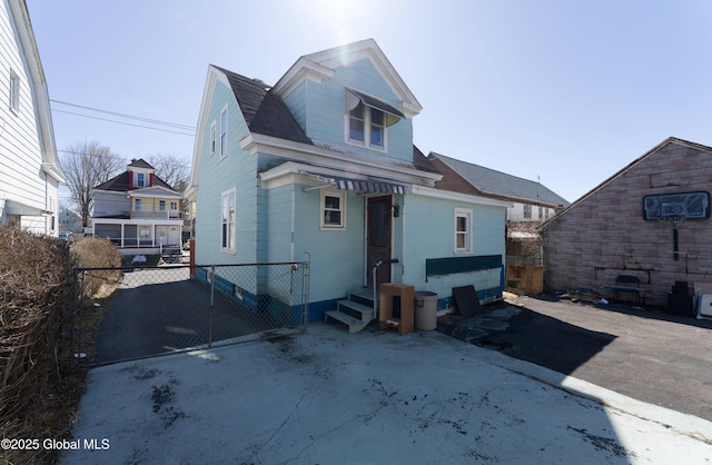 back of property featuring entry steps, a shingled roof, and fence