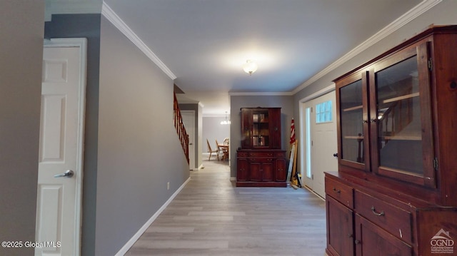 corridor with stairs, baseboards, light wood-style flooring, and crown molding