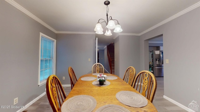 dining area featuring an inviting chandelier, crown molding, baseboards, and wood finished floors